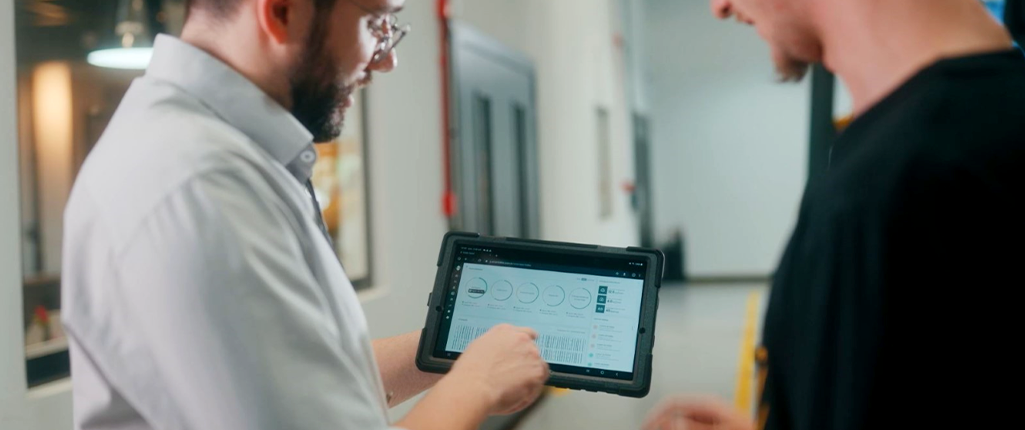 Homens utilizando um tablet para visualizar o Smart in Line