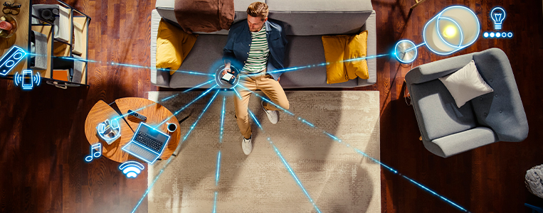 Homem sentado no sofá em uma casa inteligente.