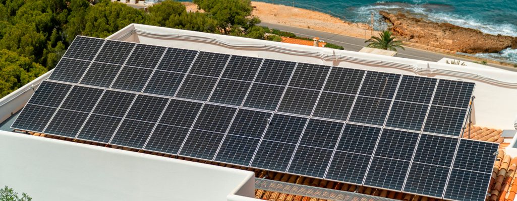 Painéis solares no telhado de uma casa na praia.
