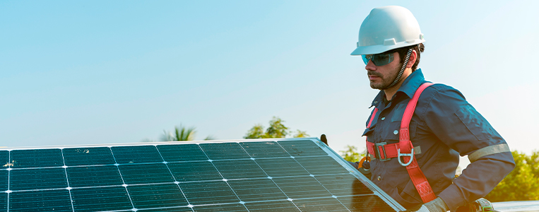 Integrador solar inspecionando a instalação de painéis solares.