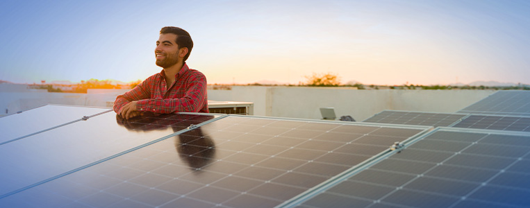 Homem se apoiando em painel solar.