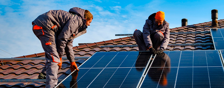 Integradores solares instalando painéis solares.