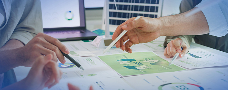 Papéis com gráficos e tabelas sobre mesa.
