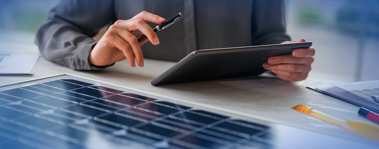 Pessoa usando tablete e smartphone em escritório com materiais de trabalho, destacando tecnologia e inovação.