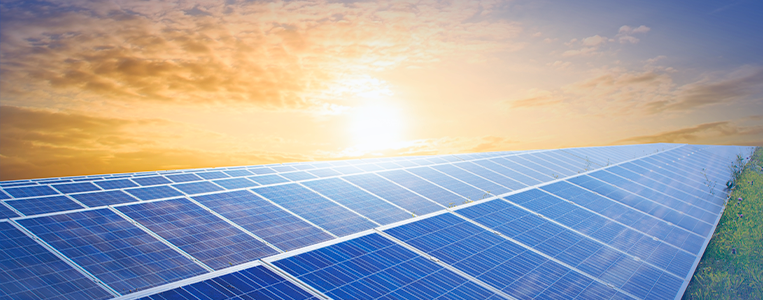 Painel de energia solar voltado para energia renovável ao pôr do sol, simbolizando sustentabilidade e uso de tecnologia limpa.