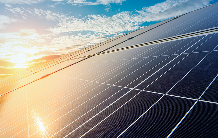 Painel de energia solar fotovoltaica em campo aberto, capturado ao pôr do sol, promovendo energia renovável e sustentável para o futuro.