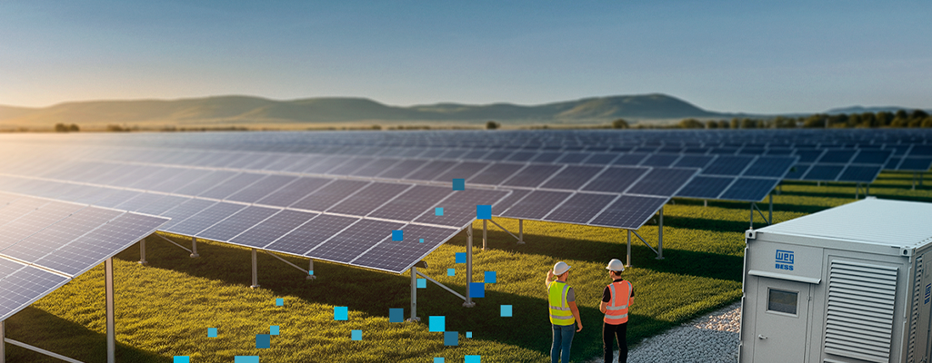 Dois técnicos com capacete inspecionam uma usina solar com fileiras de painéis; ao lado, um contêiner/equipamento industrial, sugerindo operação e novas oportunidades no setor.