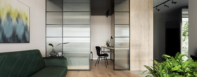 Sala e home office com divisória de vidro.