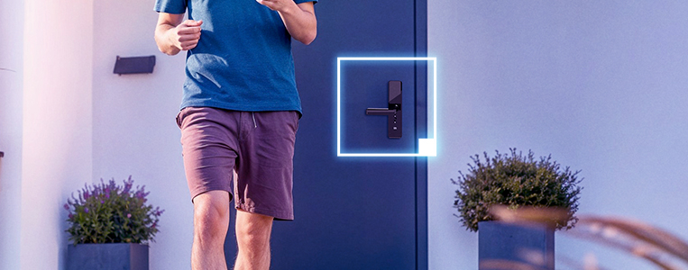 Homem segurando uma caixa de correios inteligente ao lado de uma porta com fechadura eletrônica na residência.