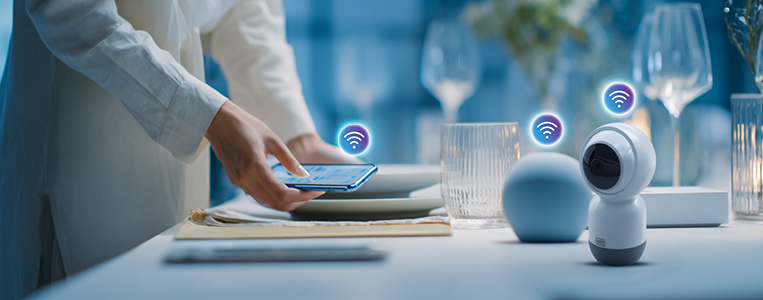 Pessoa controlando dispositivo inteligente em uma mesa de jantar moderna com tecnologia de conexão Wi-Fi, evidenciando a automação residencial.